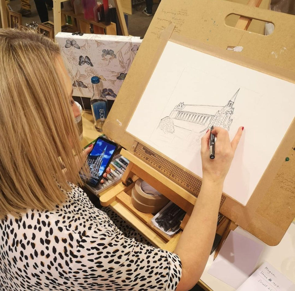 Sam Bratby artist drawing a building with ink on an easel